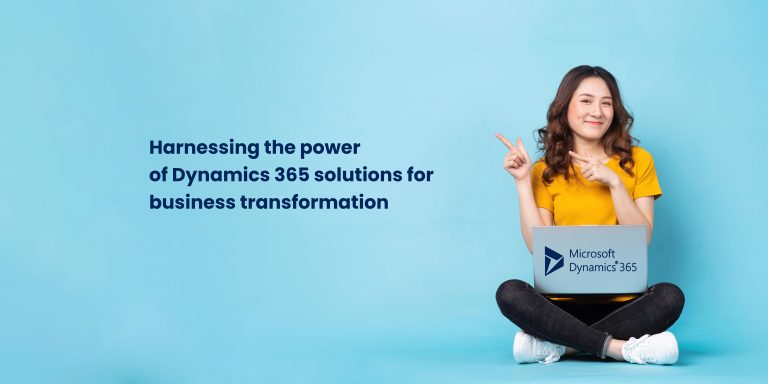 A young woman sitting cross-legged on the floor, smiling and pointing to the side. She is using a laptop with the Microsoft Dynamics 365 logo on the screen. The background is a light blue color.