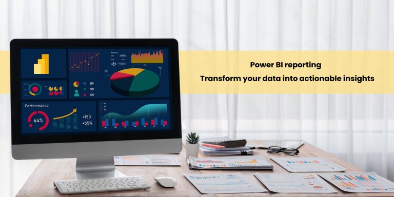 A computer monitor displaying a Power BI dashboard with various colorful charts and graphs, set on a wooden desk alongside papers and a pair of glasses.